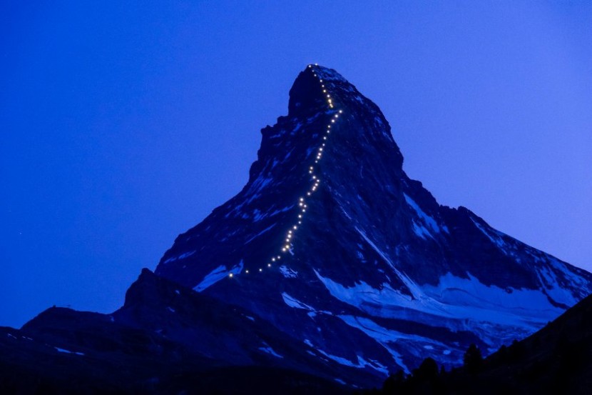 In this picture made available Thursday, July 9, 2015, lamps illuminate the path of the first ascent on the Matterhorn mountain, in Zermatt, Switzerland, late Wednesday, July 8, 2015. On the 14th of July, Zermatt celebrates 150 years since the first ascent of the Matterhorn mountain 4,478 metres above sea level. (Jean-Christophe Bott/Keystone via AP)